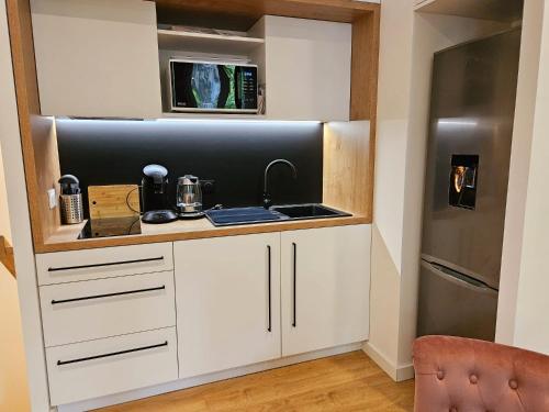 une cuisine avec un évier et un réfrigérateur dans l'établissement Luxine One - Appartement 4 pers - Entre Canal et Gare Matabiau, à Toulouse