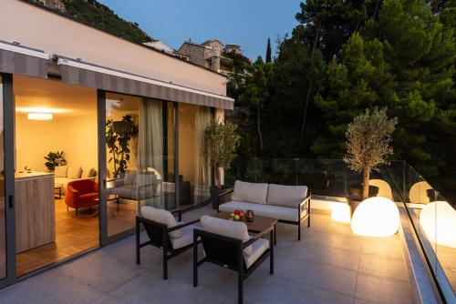 a patio with a couch and chairs and a table at Vertmont Villa in Sveti Stefan