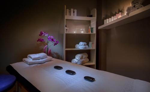 a spa room with towels and a shelf with flowers at Hotel RH Vinaros Playa & Spa 4* Sup in Vinaròs
