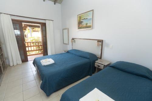 a bedroom with two beds and a balcony at Pousada Mata Atlantica Juquehy in Juquei