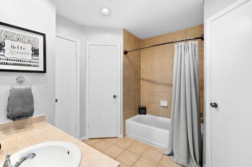 a bathroom with a tub and a sink and a shower at Pet Friendly - Q2 & Domain - King Bed - Pool Table in Austin