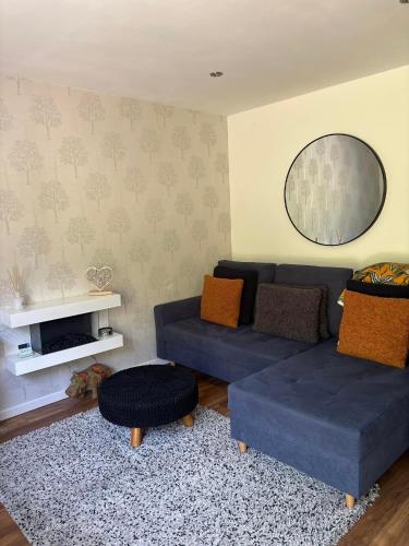 a living room with a blue couch and a rug at Secret Gem 1 Bed Garden Flat Private Luxury Hot Tub in Bournemouth