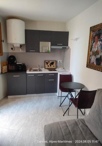 une cuisine avec un évier et une table avec des chaises dans l'établissement Chante Brise Studio, à Cannes