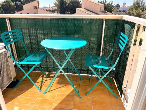 deux chaises et une table sur un balcon dans l'établissement les villageoises, au Barcarès