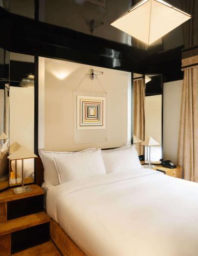 une chambre avec un grand lit avec des oreillers blancs dans l'établissement Hôtel Château d'Eau, à Paris