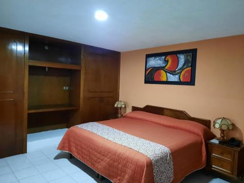 a bedroom with a bed and a painting on the wall at Hotel San Fernando Ciudad Valles in Ciudad Valles