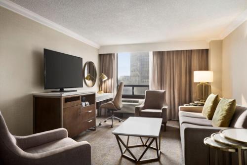 a hotel room with a television and a couch and chairs at Crowne Plaza Toronto Airport by IHG in Toronto