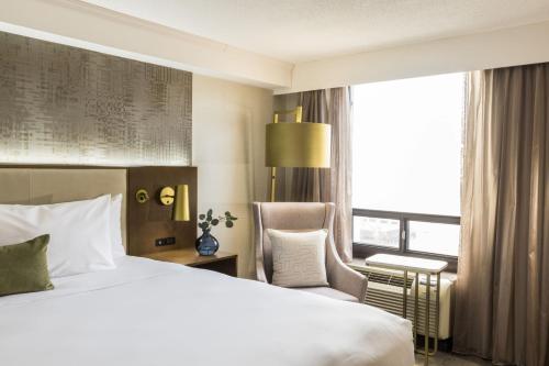 a hotel room with a bed and a chair and a window at Crowne Plaza Toronto Airport by IHG in Toronto