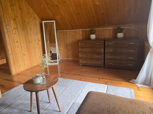 a room with a dresser and a table with a mirror at Domek na skraju lasu in Płaska