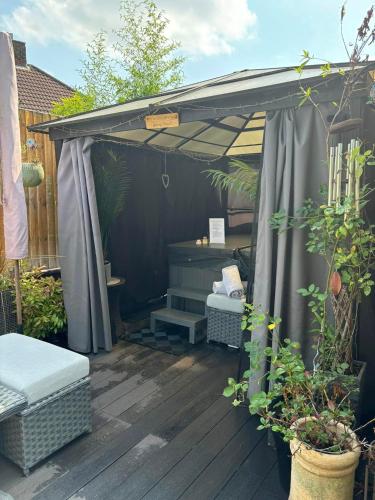 a black pergola with a bench and a table at Secret Gem 1 Bed Garden Flat Private Luxury Hot Tub in Bournemouth