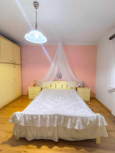 a bedroom with a large bed with a white canopy at Το Αρχοντικό Της Βέτας Στον Όλυμπο! in Pýthion