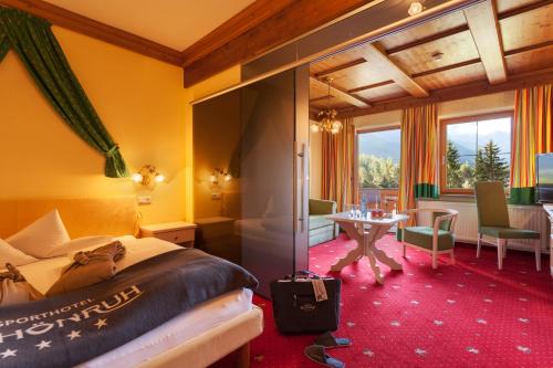 a hotel room with a bed and a table at Sporthotel Schönruh in Ehrwald