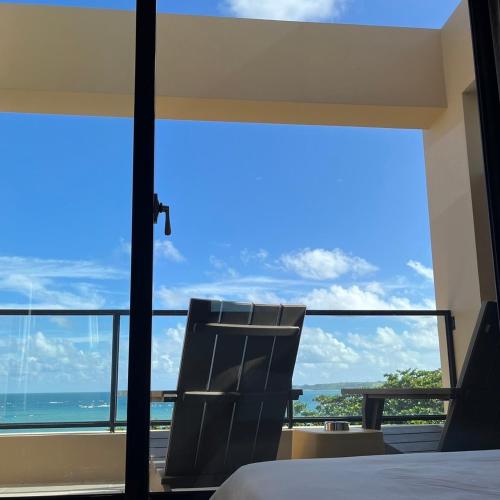 a bedroom with a bed and a view of the ocean at Okkar Inn in Nanwan