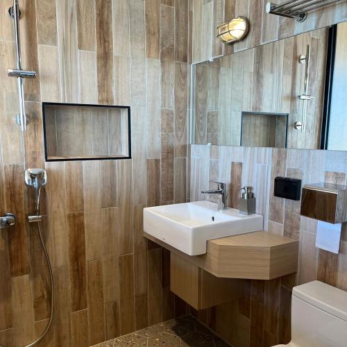 a bathroom with a sink and a shower and a toilet at Okkar Inn in Nanwan