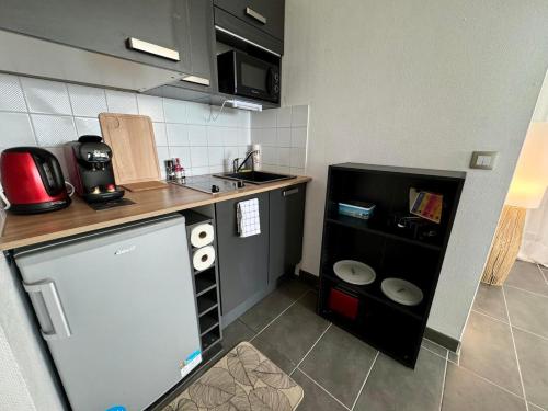 une petite cuisine avec un comptoir et un évier dans l'établissement la voile de mer - studio tout confort proche plage, à La Rochelle