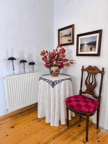 a table with a vase of flowers and a chair at Το Αρχοντικό Της Βέτας Στον Όλυμπο! in Pýthion