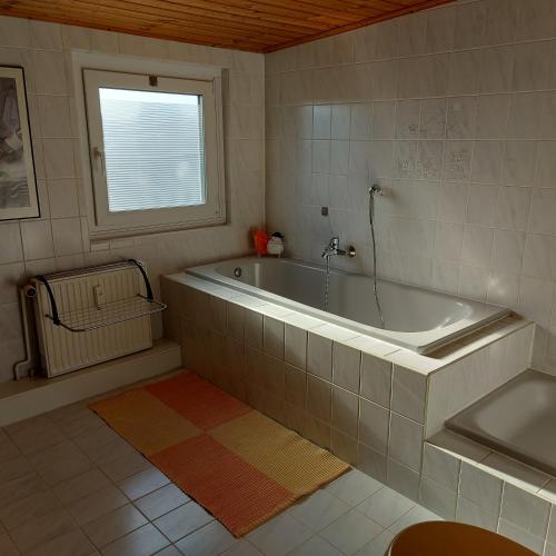 a bathroom with a tub and a window at Flensburg Ferienwohnung Apartment nähe Zentrum und Uni in Flensburg