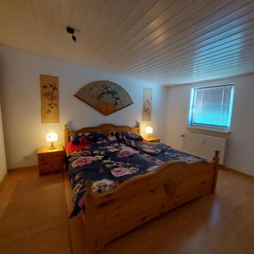 a bedroom with a wooden bed and two lamps at Flensburg Ferienwohnung Apartment nähe Zentrum und Uni in Flensburg