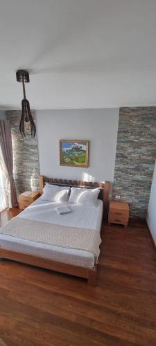 a bedroom with a white bed and a brick wall at Nurellari Winery Cellar and Guest House in Berat