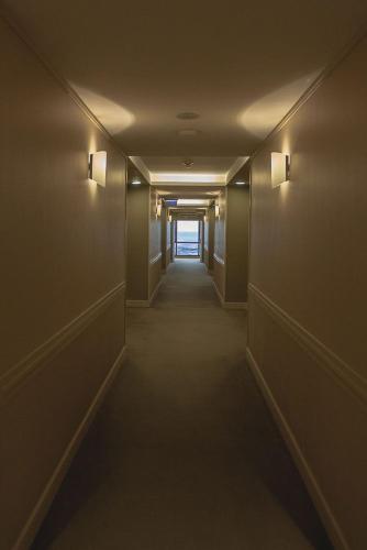 a hallway with a long corridor with lights on the walls at Austral Plaza Hotel in Comodoro Rivadavia