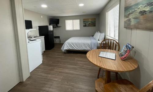 a small room with a bed and a table and a kitchen at Sunset Beach Resort in Osage Beach