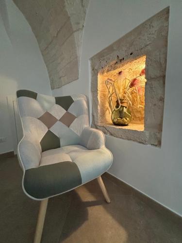 a chair sitting in a room with a fireplace at Forno Mongelli 2.0 in Putignano