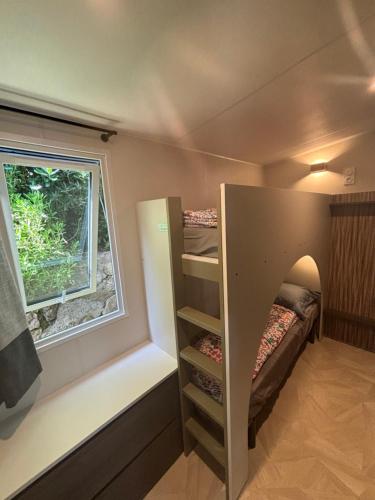 Cette petite chambre comprend des lits superposés et une fenêtre. dans l'établissement Bungalow de Luxe, New, Top-of-the-range amenities, Air conditioning, Jacuzzi and Sea view, à Saint-Raphaël