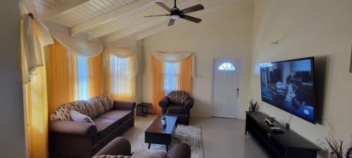 a living room with two couches and a flat screen tv at Ocean View Get Away in Falmouth