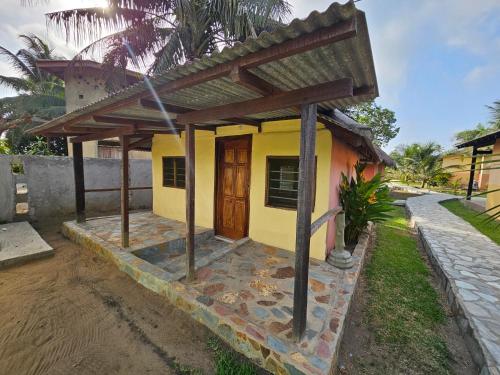 a small yellow house with a wooden door at Uzoma's Lodge in Butre