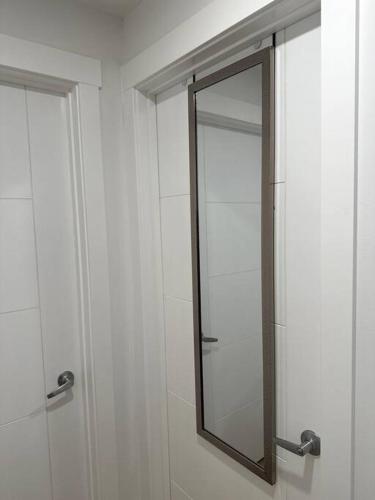 a mirror on a wall in a bathroom at Stylish & Modern 2 Bedroom Suite in Regina