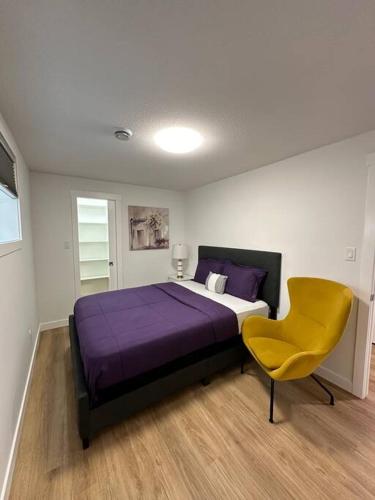 a bedroom with a bed and a yellow chair at Stylish & Modern 2 Bedroom Suite in Regina