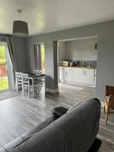 a living room and kitchen with a couch and a table at Chapel Cottage in Bramfield