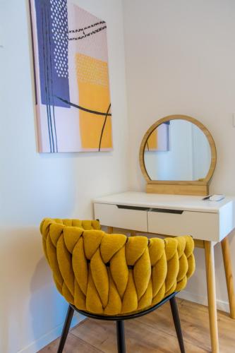 a yellow chair in front of a desk with a mirror at Apartment Paradise Island in Pučišća