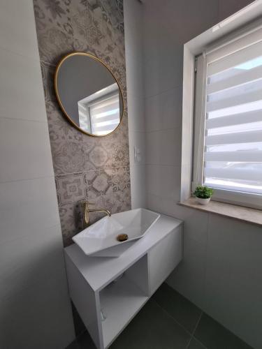 a bathroom with a white sink and a mirror at Apartament z dużym ogródkiem in Rzeszów