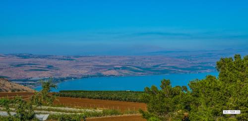 a view of a blue lake from a hill at Beautiful Countryside House in Tiberias