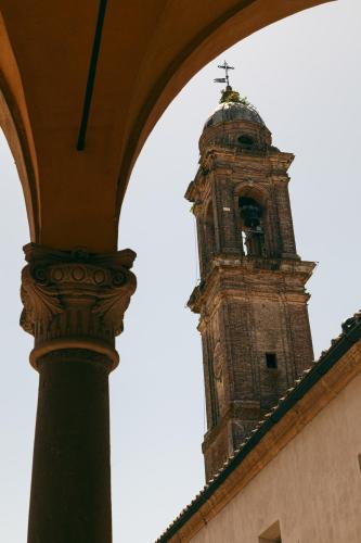 a clock tower with a cross on top of a building at Hotel Certosa Di Maggiano in Siena