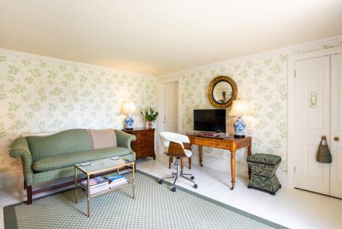 a living room with a green couch and a television at Dun Brae Cottage in Dornoch