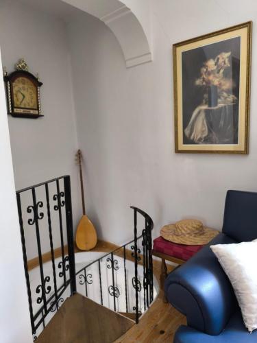 a living room with a blue couch and a clock at Το Αρχοντικό Της Βέτας Στον Όλυμπο! in Pýthion
