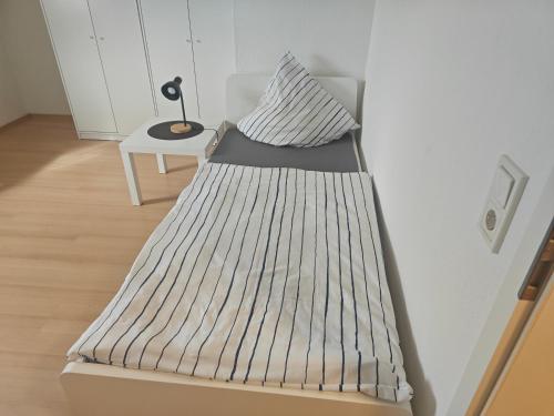 a bed in a room with a pillow and a table at Work and Stay Eschweiler 80 Qm 5 Betten 2 Schlafzimmer,Neu in Eschweiler