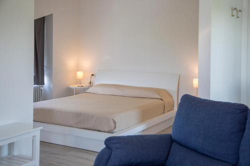 a bedroom with a bed and a blue chair at Hotel San Francesco in Borgomanero