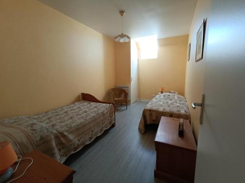 une chambre d'hôtel avec deux lits et une table dans l'établissement Maison près de la Rance dans un village, à Taden