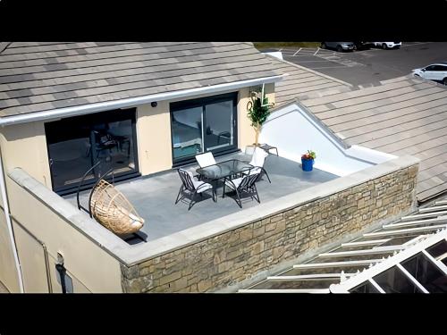a patio with a table and chairs on top of a house at Fabulous 3-bedroom home across St Michaels Mount in Marazion