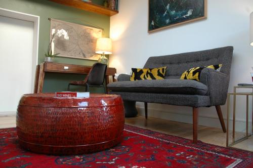 a living room with a couch and a ottoman at Augusta Boutique House in Lisbon