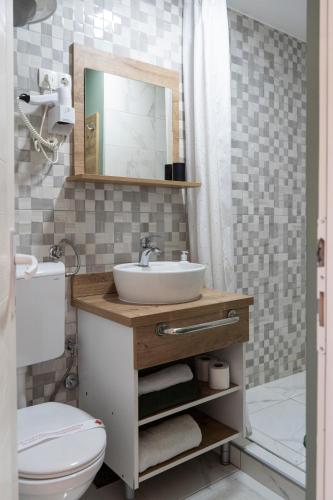 a bathroom with a sink and a toilet and a mirror at Guest House Time Out in Sarajevo