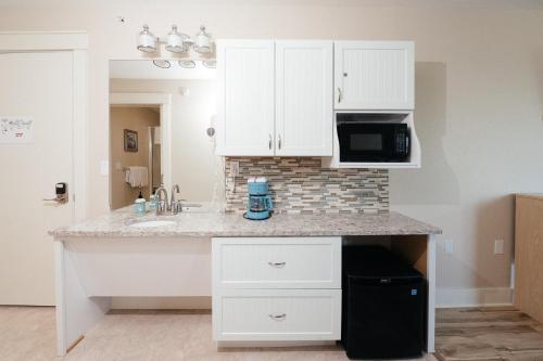 a kitchen with white cabinets and a counter top at Kasa Gold Coast Inn Traverse City in Traverse City