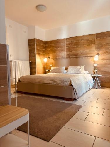 Un dormitorio con una cama grande con paredes de madera. en Apart Hotel Atlantic, en Grado