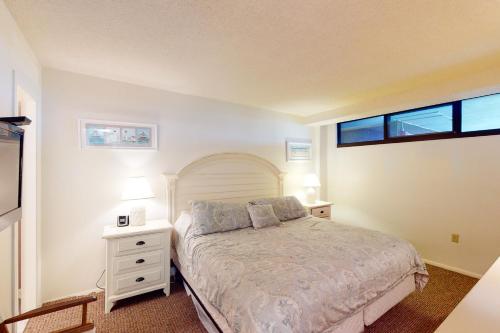 a bedroom with a bed and two tables and two windows at Sea Colony - 709 Dover House Rd. in Bethany Beach