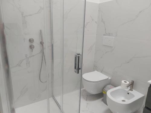 a white bathroom with a shower and a toilet at Sweet home in Priolo Gargallo