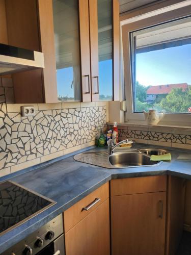 a kitchen with a sink and a window at Querenhorst, Unterkunft am Feld in Querenhorst