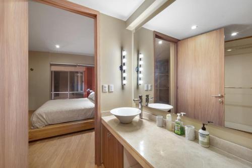 a bathroom with a bed and a sink and a mirror at 3 BR Upscale Art House Reforma Avenue in Mexico City